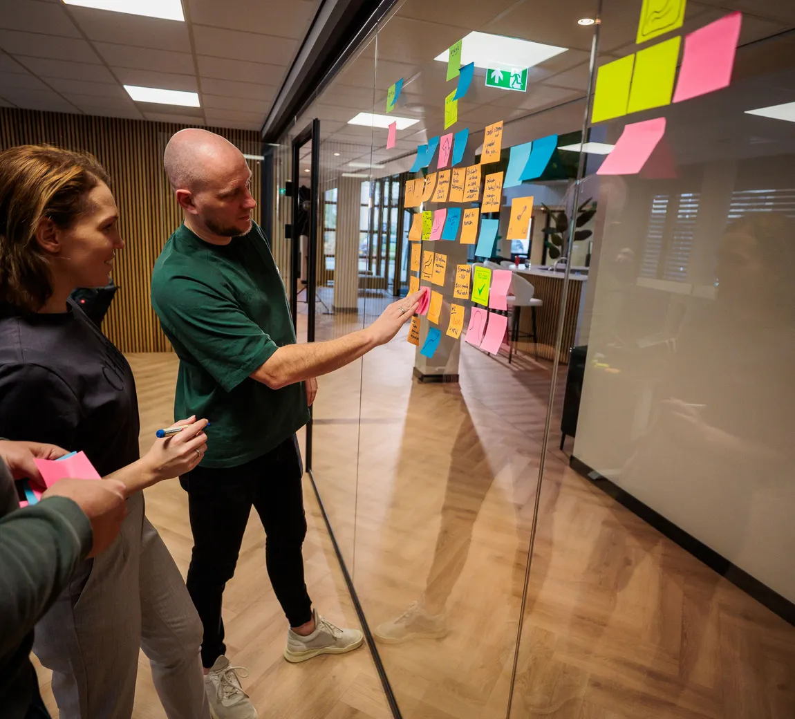 Workshop met post-its op een glazen wand